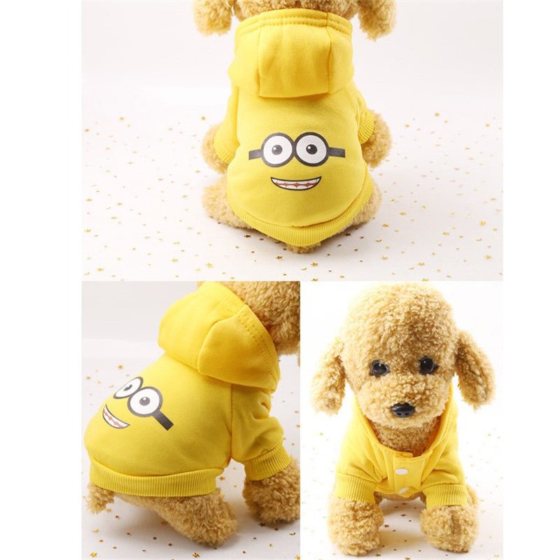 Small dog wearing yellow cartoon hoodie sweater with smiling face design