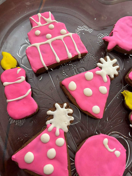 Birthday Girl Organic Dog Cookies with pink and white icing in birthday-themed shapes