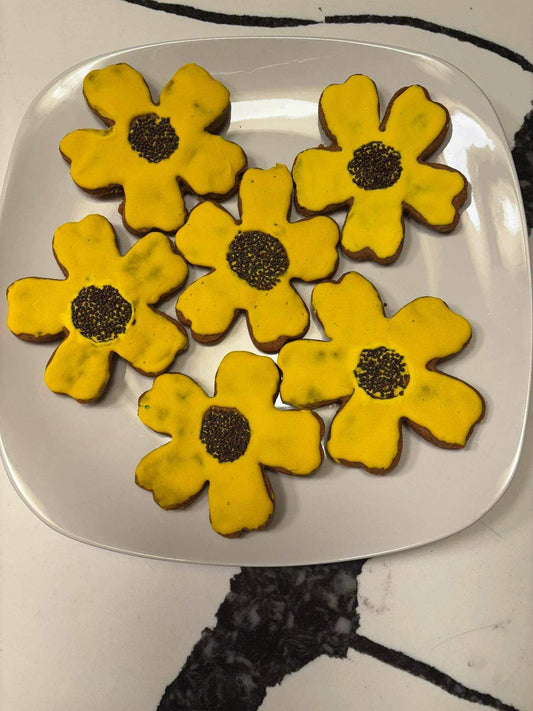 Organic Sunflower Peanut Butter Cookies with yellow glaze and black sesame seed centers on white plate