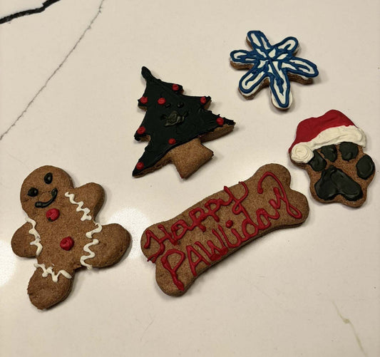 Christmas dog peanut butter cookies shaped like festive holiday treats on a wooden board