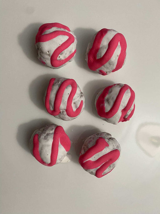 Organic Bon Bon Dog Treats with white coating and pink drizzle, bite-sized and made from natural ingredients for dogs