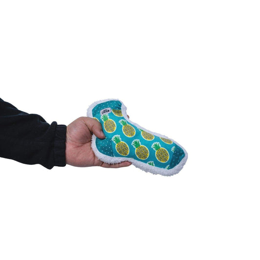 Hand holding Squeaky Sock Plush Dog Toy with pineapple design against white background