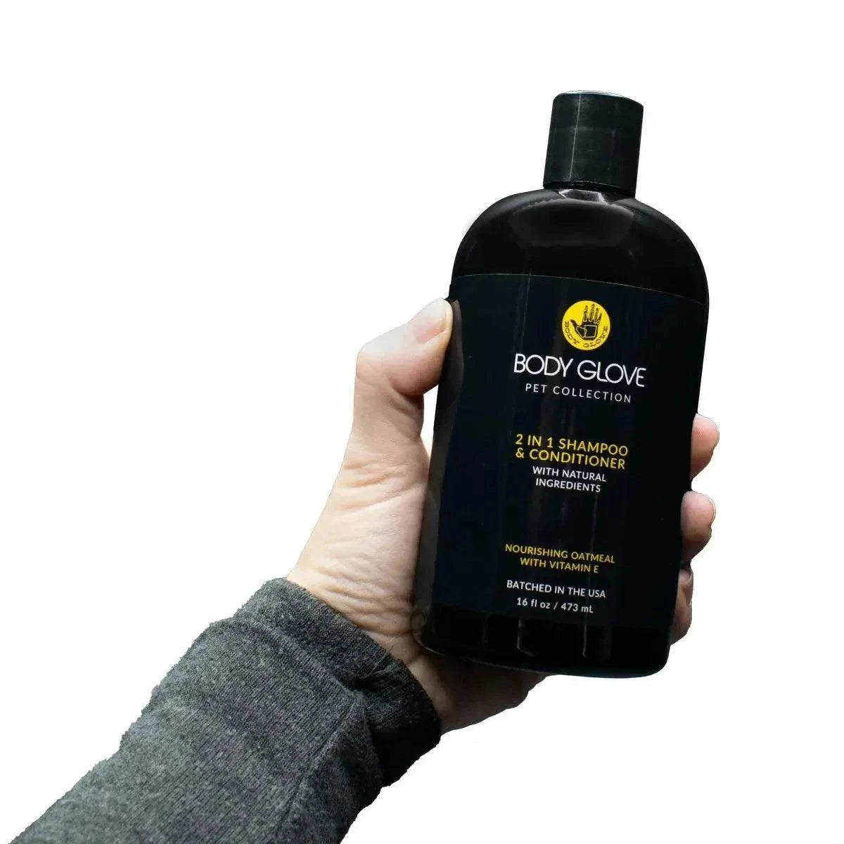 Hand holding Body Glove 2-in-1 Pet Shampoo and Conditioner bottle with natural ingredients and nourishing oatmeal label