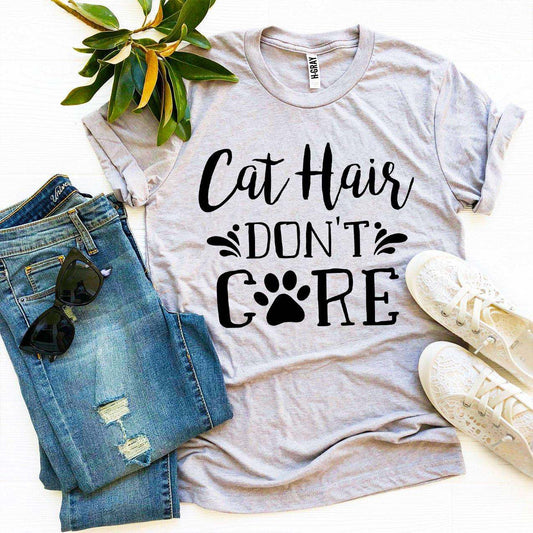 Gray Bella Canvas Cat Hair Don't Care T-shirt with black text and paw print, paired with blue ripped jeans, sunglasses, and white sneakers on a white background