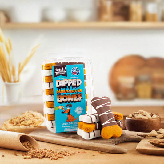 Dipped Bones peanut butter dog treats with yogurt icing on wooden board in kitchen setting