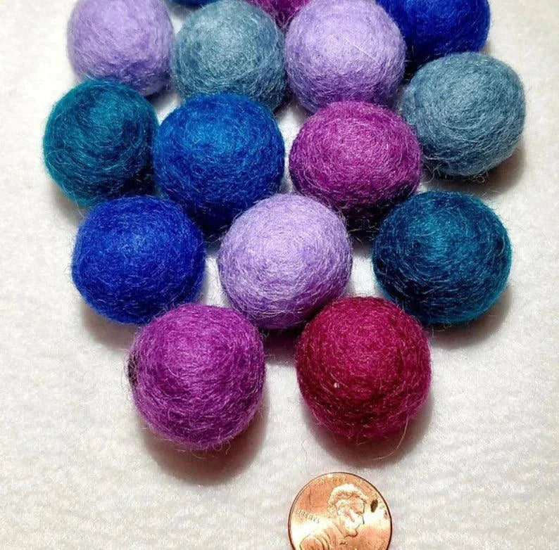 Assorted organic wool cat toy balls in a tin case made from 100% natural wool and dyed with organic dyes