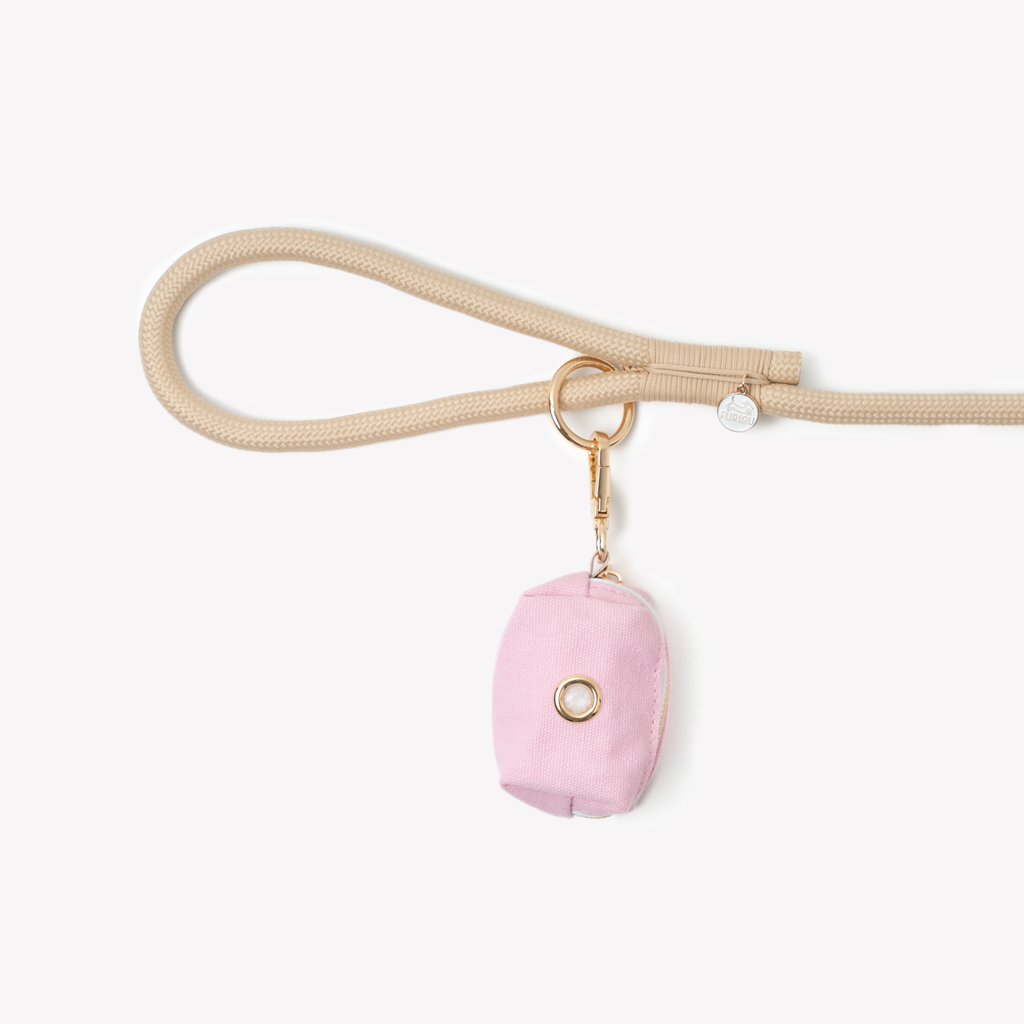 Pink poop bag holder pouch clipped to a beige dog leash loop with gold hardware.