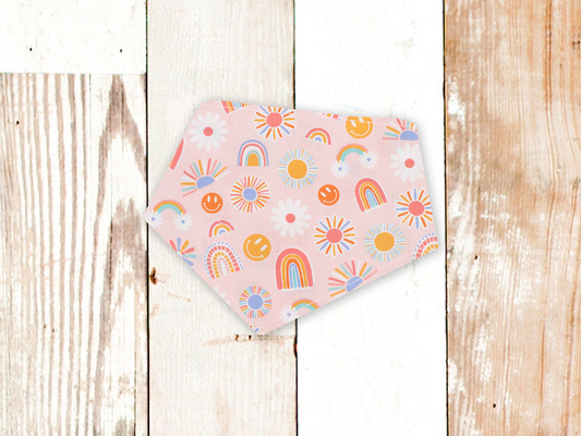 Happy Sunshine Dog Bandana with colorful sun, rainbow, and smiley face patterns on pink fabric, adjustable snap closures