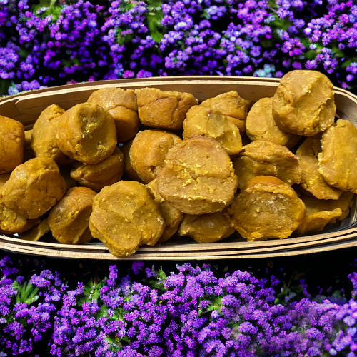 Basket of organic pumpkin muffins for dogs with soft texture, made from human-grade ingredients, displayed on purple flowers background