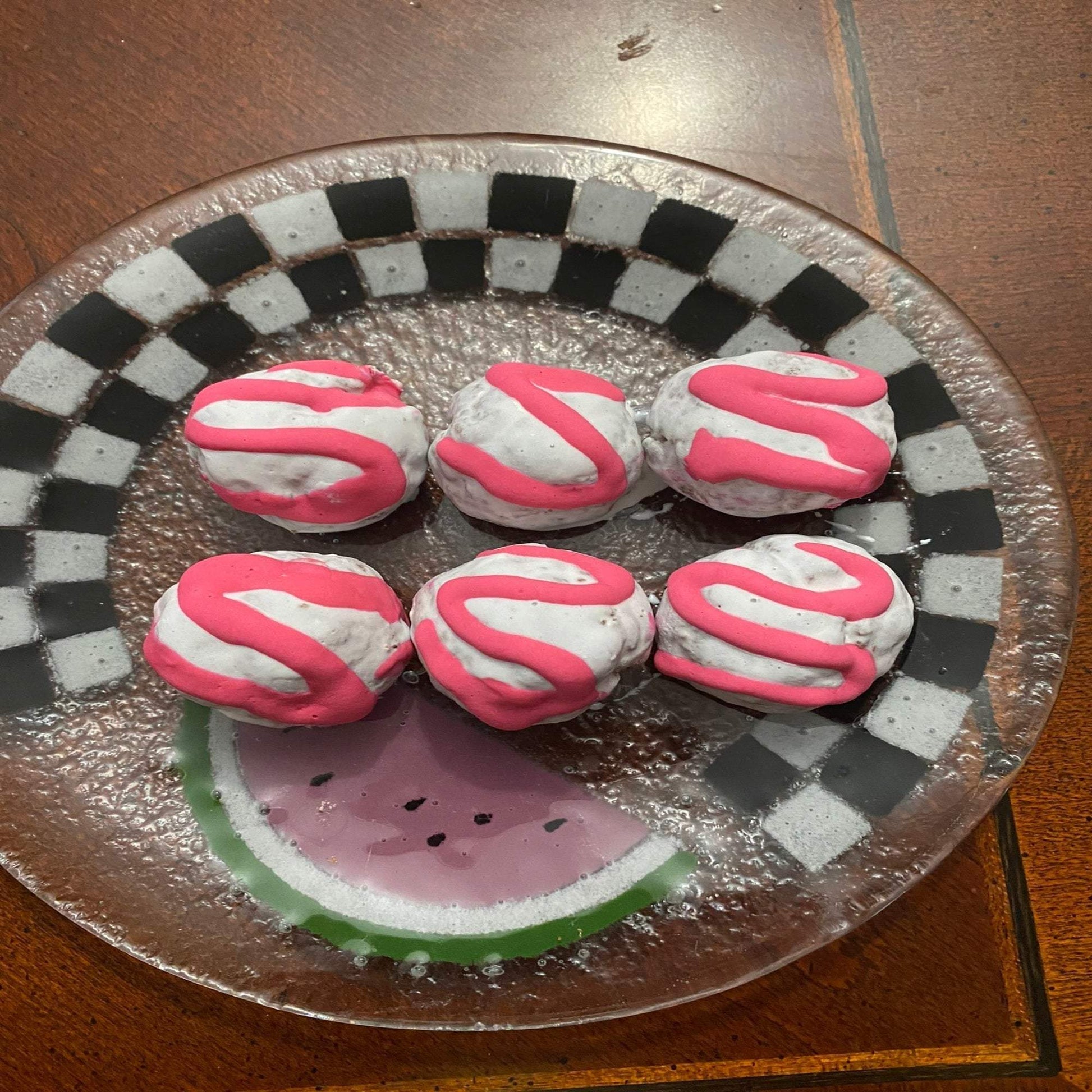 Organic Bon Bon Dog Treats with pink icing on checkered glass plate