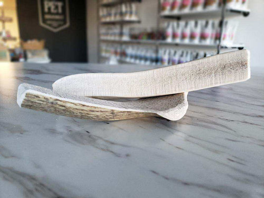 Large split elk antler dog chew on marble countertop in pet store environment