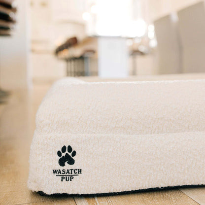 Luxury orthopedic dog bed with memory foam, plush boucle cover, and raised bolsters for comfort and support
