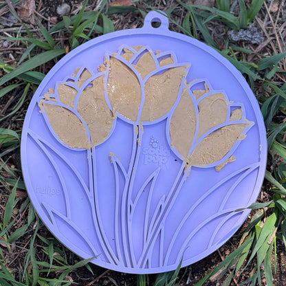 Light purple tulip design enrichment lick mat with peanut butter for dogs, featuring suction cups and multi-texture surface for slow feeding and anxiety relief