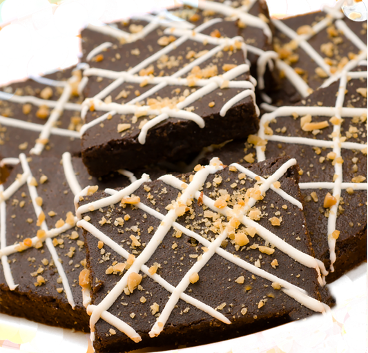 Brownie organic dog treats with white drizzle and nut topping, soft and chewy pet snacks made from all-natural ingredients.