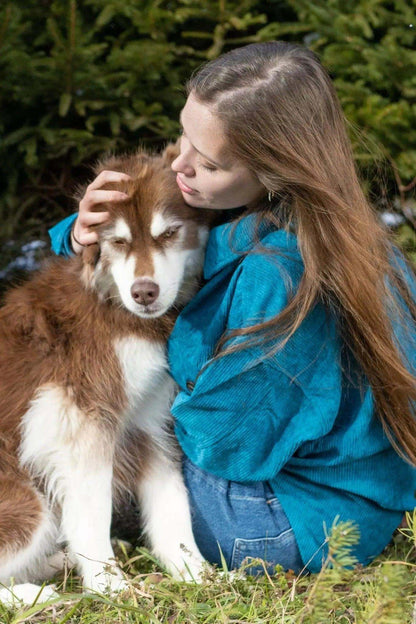 Dog wearing Blue Spruce Plaid Dog Bandana cuddled by woman outdoors