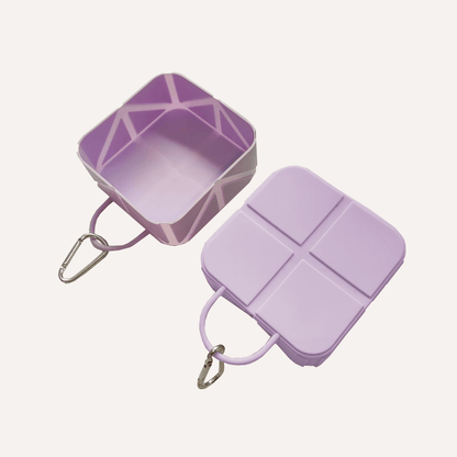 Compact foldable pet food and water bowl in purple with carabiner clip for travel convenience