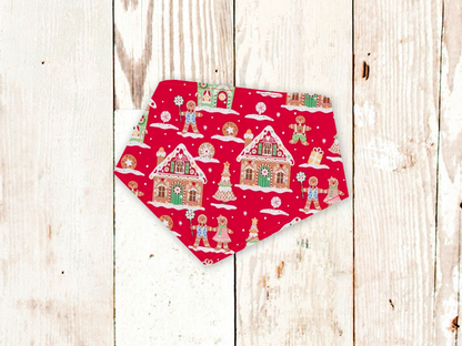 Adjustable Gingerbread House dog bandana with snap closures and flannel backing on red background