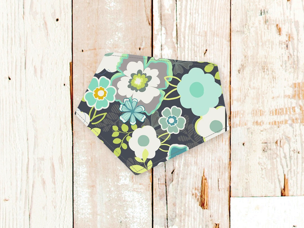 Grey flowers dog bandana with adjustable snap closures and white flannel backing on wooden background