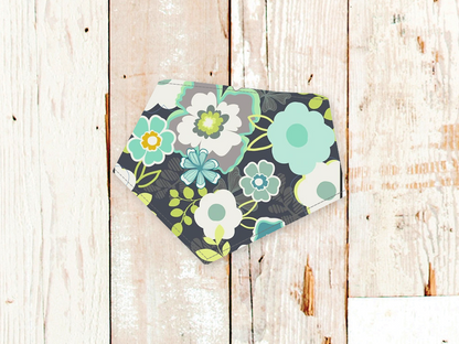 Grey flowers dog bandana with adjustable snap closures and white flannel backing on wooden background