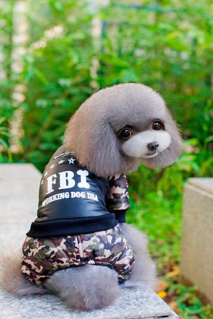 Small dog wearing FBI camouflage coat and jumpsuit pants outdoors