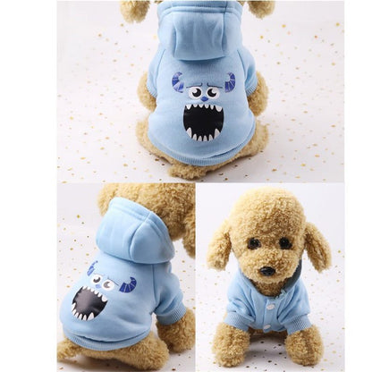 Small dog wearing a light blue cartoon hoodie sweater with monster face design and horns