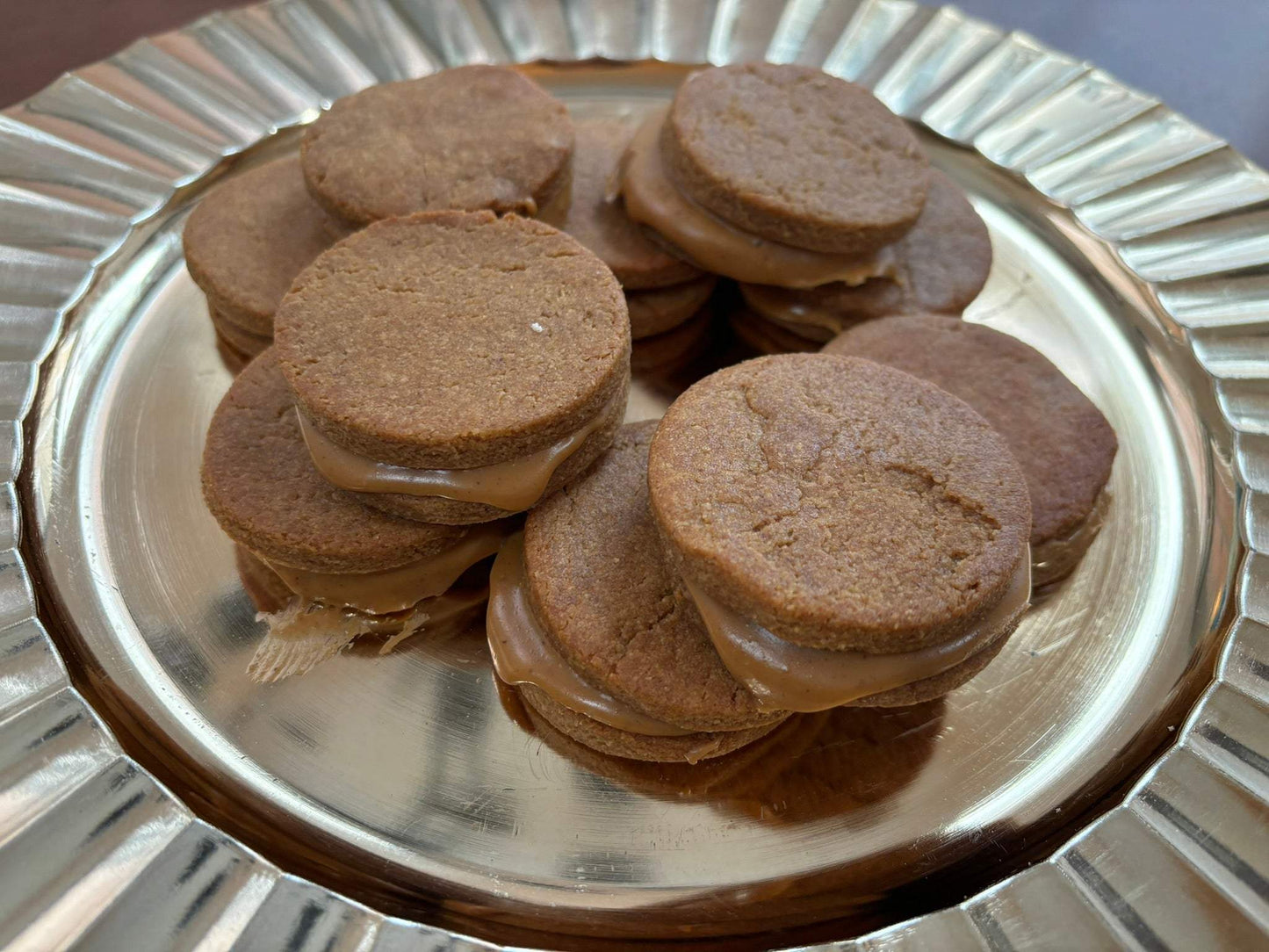 Organic peanut butter macarons dog treats stacked on a silver plate