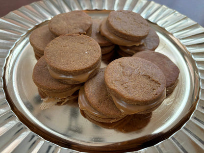 Organic peanut butter macarons dog treats stacked on a silver plate