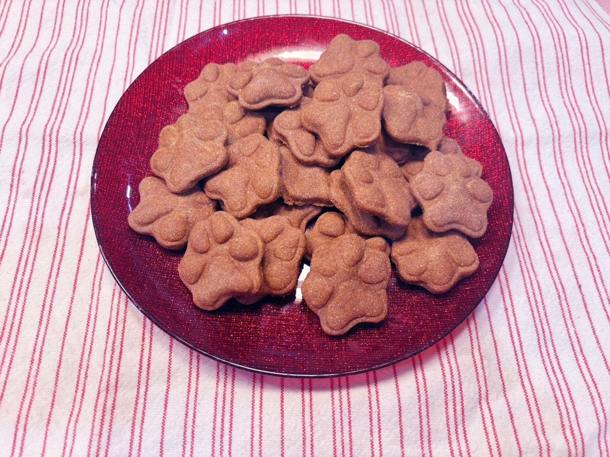 Sweet Potato Paws organic dog treats shaped like paws on a red plate