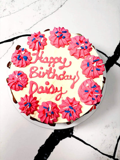 Organic dog birthday cake with pink frosting and sprinkles, personalized for Daisy