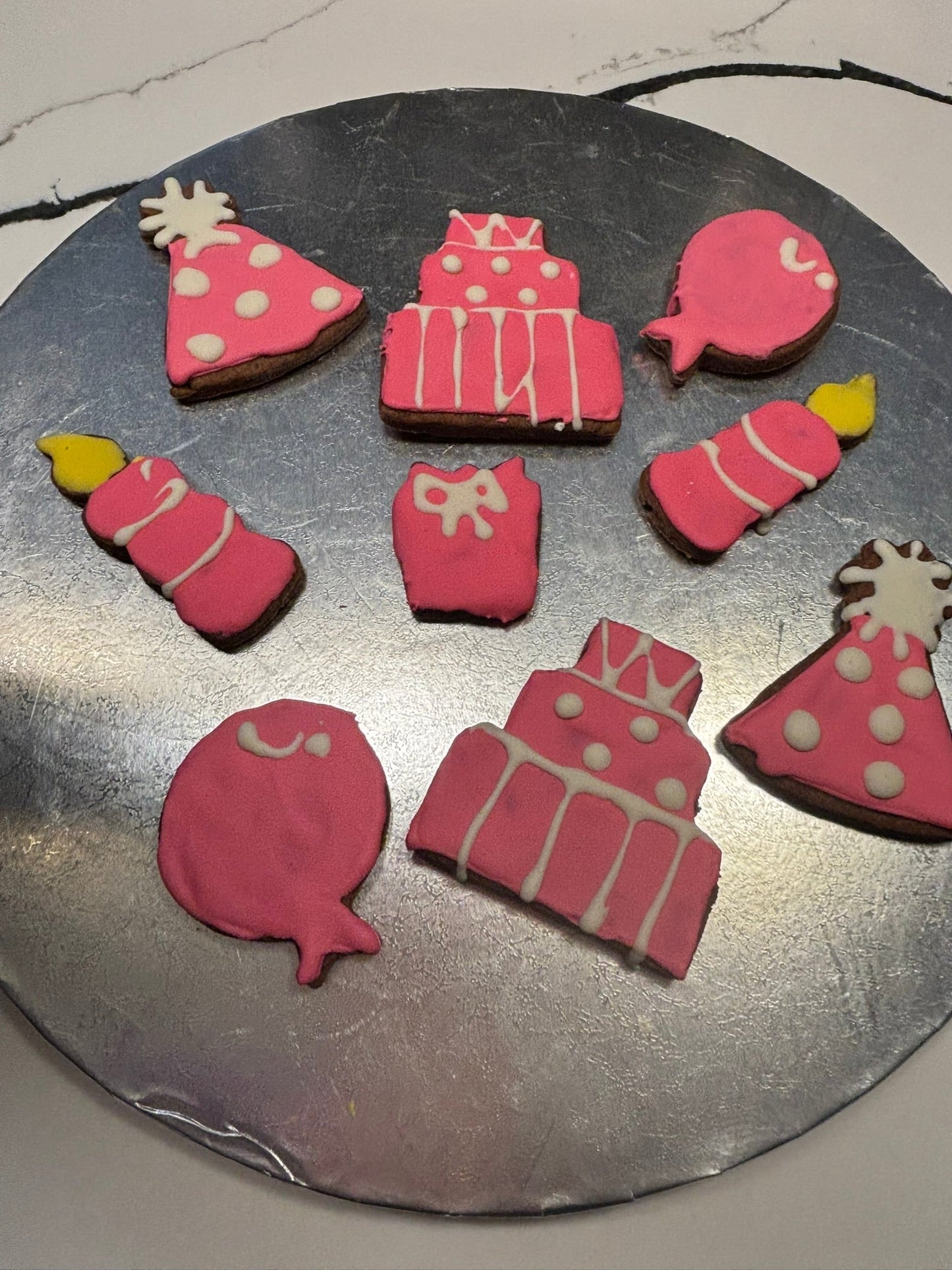Birthday Girl Organic Dog Cookies in festive pink party shapes on a silver platter