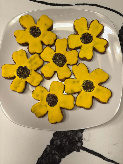 Organic Sunflower Peanut Butter Cookies with yellow glaze and black sesame seed centers on white plate