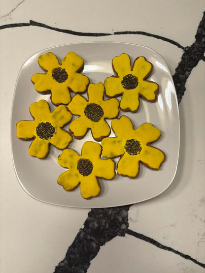 Organic Sunflower Peanut Butter Cookies with yellow glaze and black sesame seed center on white plate