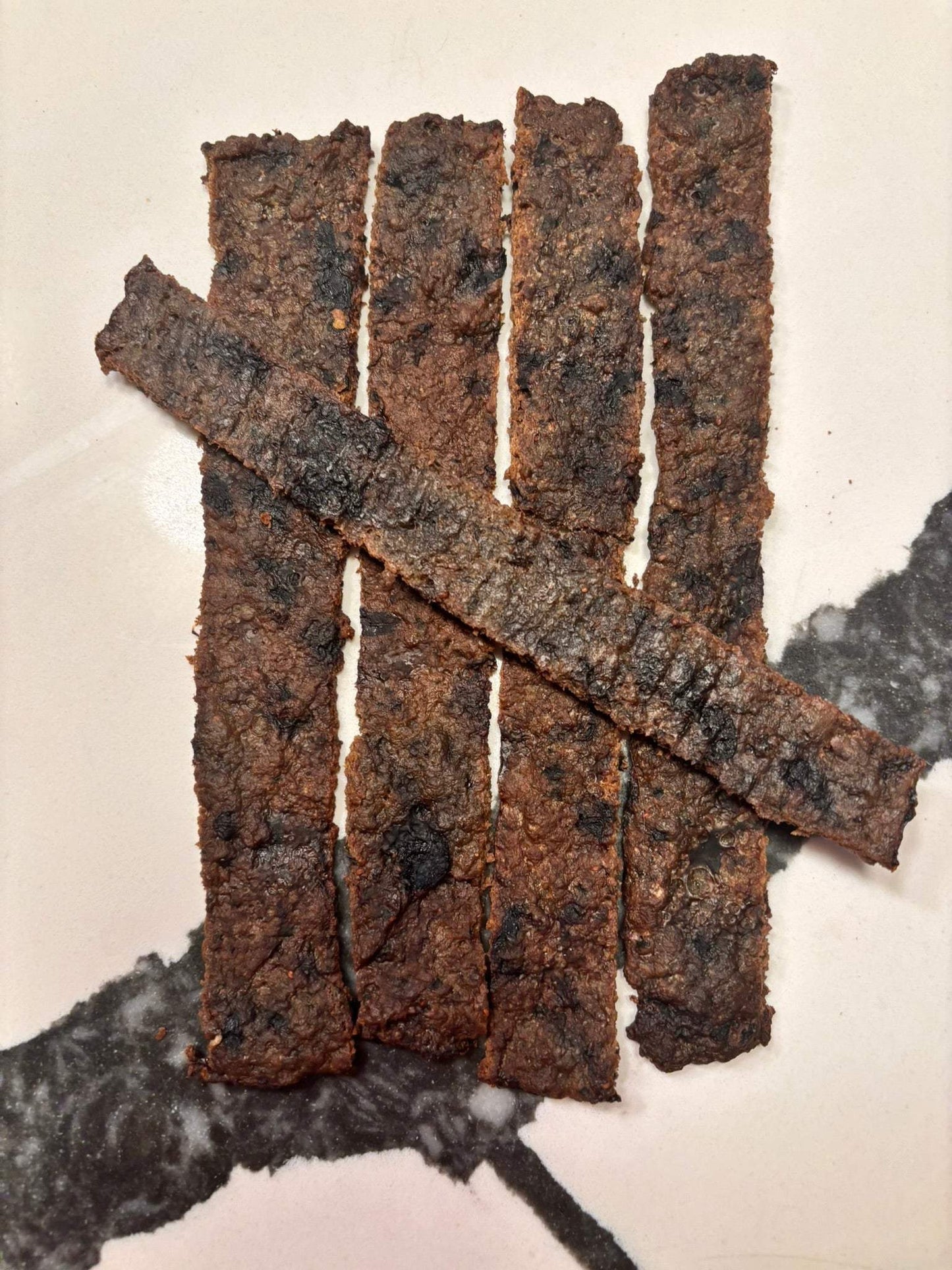 Organic blueberry beef jerky for dogs in resealable bag with high-protein human-grade beef and fresh basil