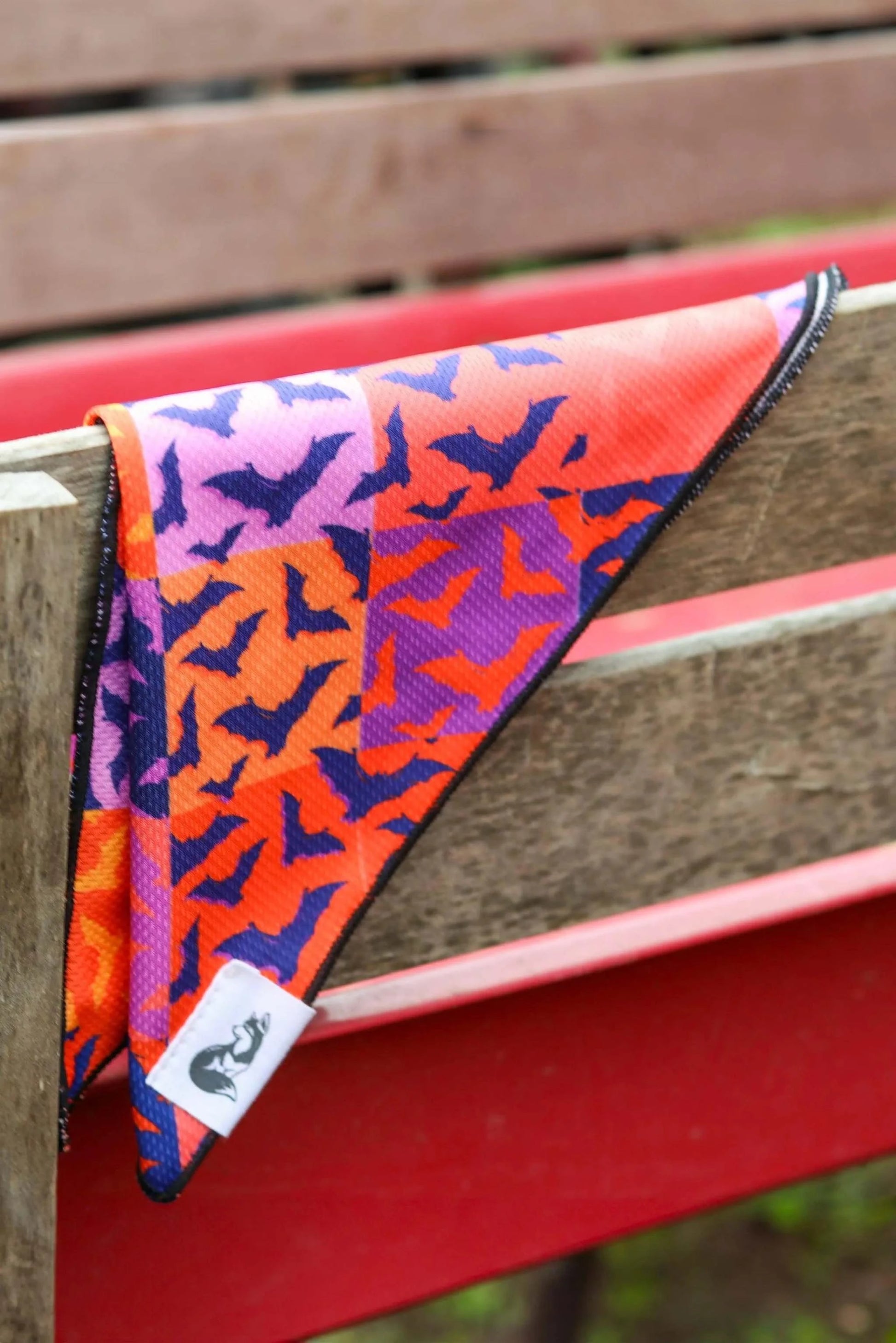Spooky Bat Squares dog bandana with purple, orange, and black bat pattern on checkered background.