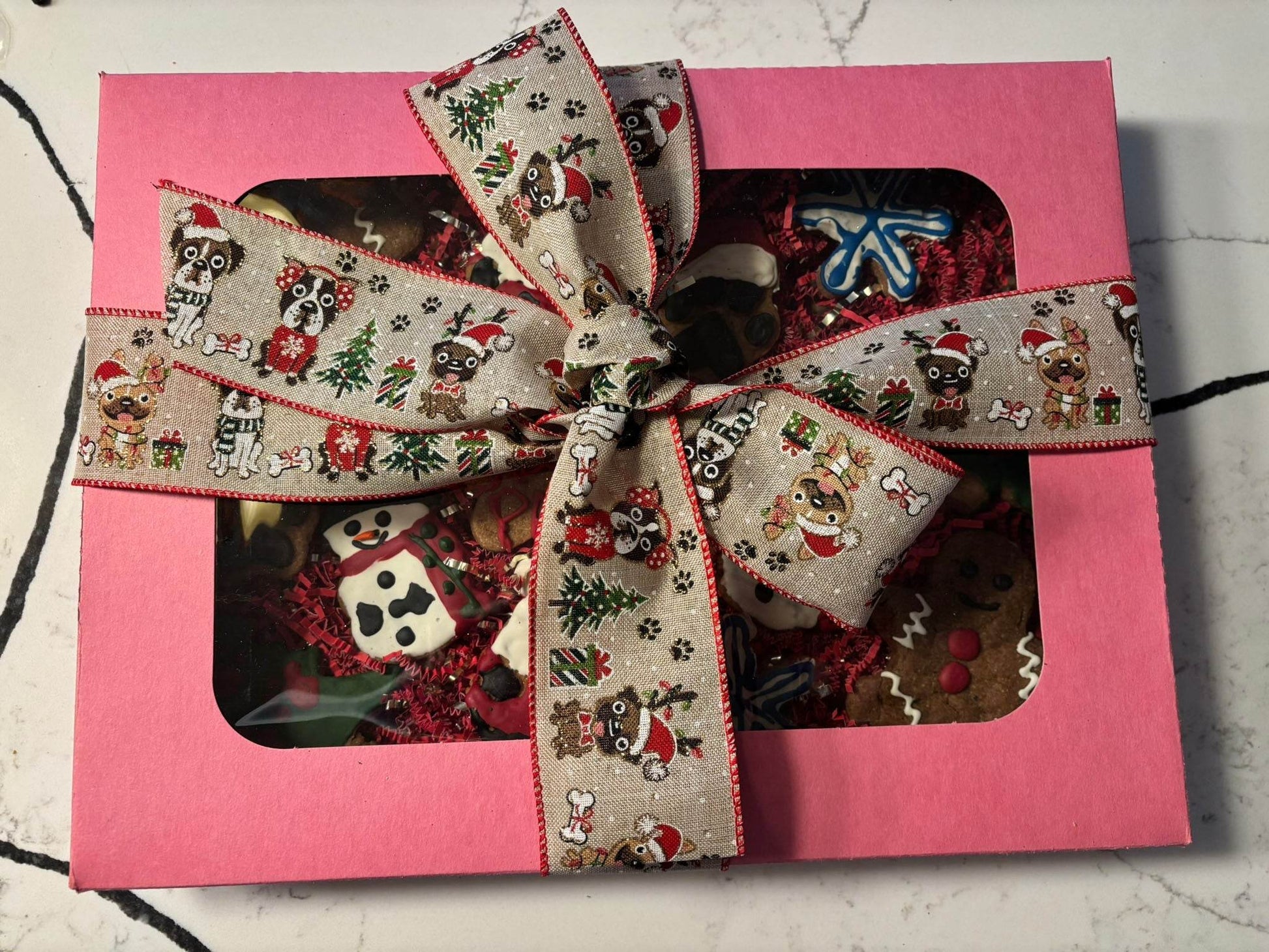 Whimsical Organic Christmas dog cookie box with festive decorated dog-safe treats in pink gift box and holiday ribbon