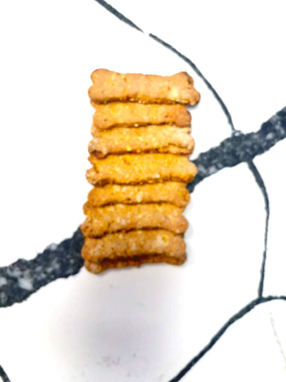 Organic Apple Carrot Bones dog treats stacked, made with apple, carrot, oats, and peanuts.