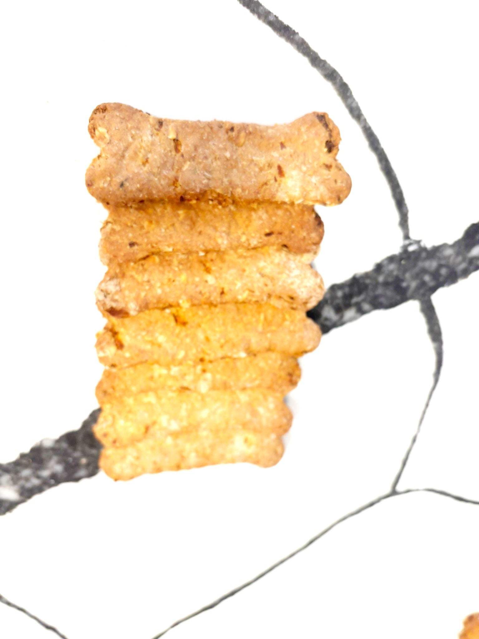 Organic Apple Carrot Bones dog treats stacked on white background
