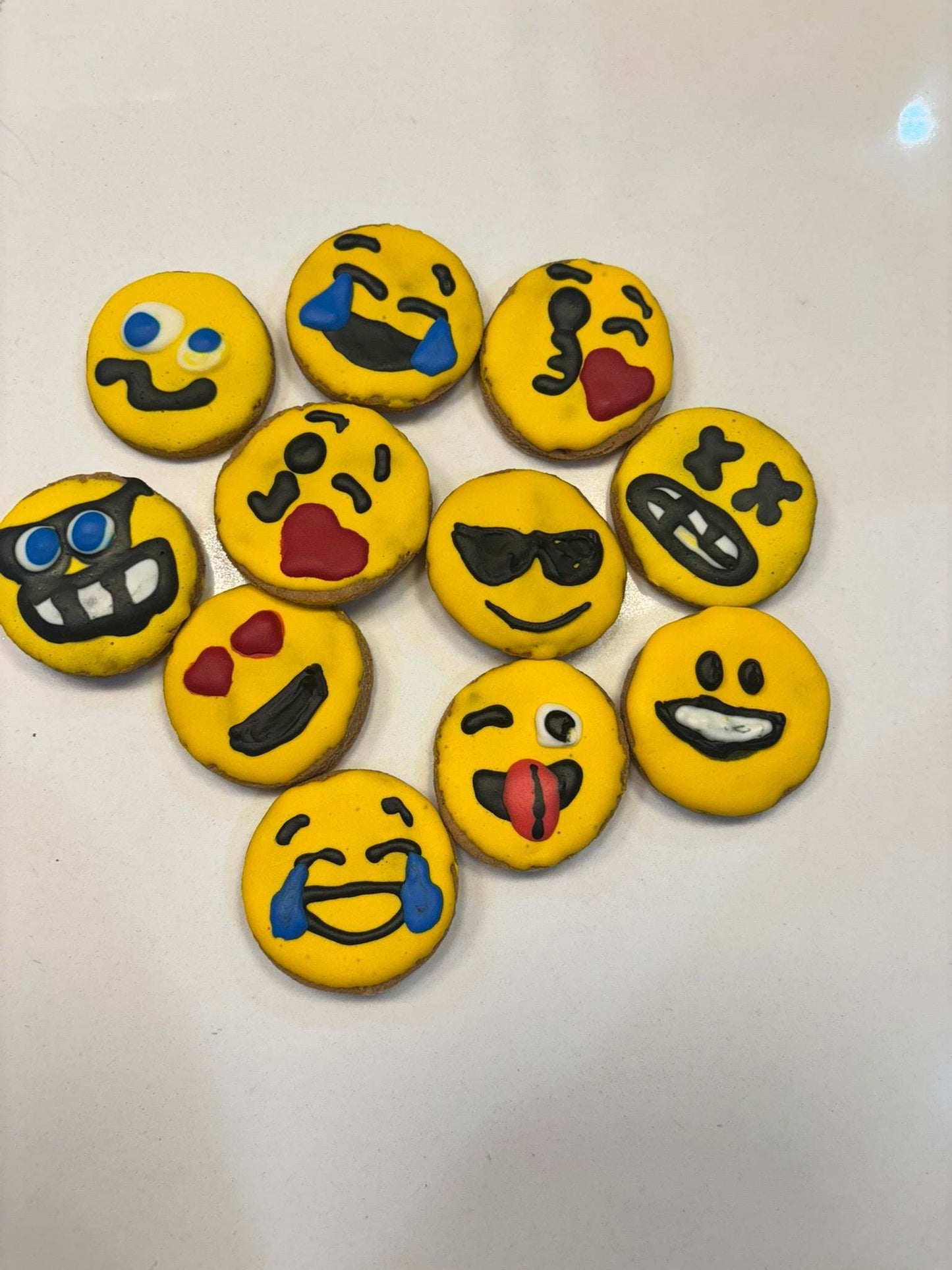 Organic peanut butter dog cookies decorated with colorful emoji faces