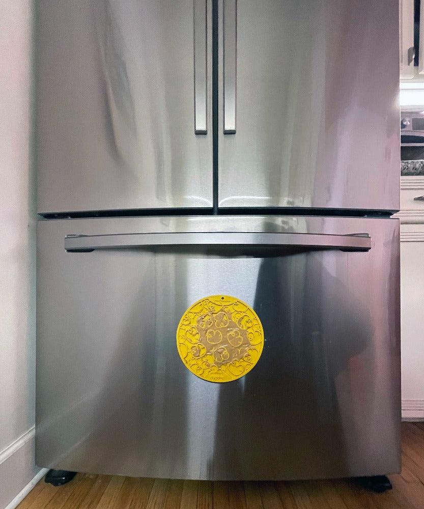 Yellow Rubber Duckies emat lick mat with suction cups attached to stainless steel refrigerator door