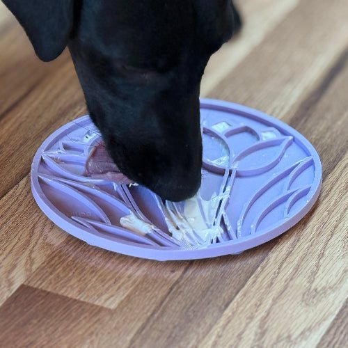 Dog using light purple Tulip Design enrichment lick mat with suction cups for slow feeding and anxiety relief