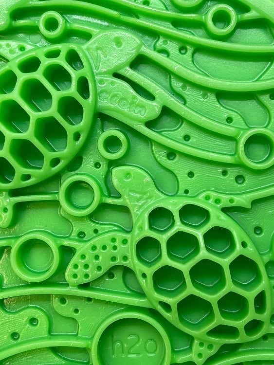Close-up of green Water eCoin nylon dog enrichment Snacking Coin  with turtle motif and textured cavities for treats