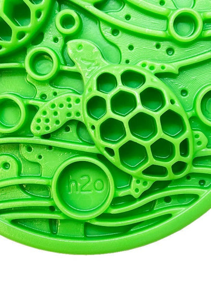 Close-up of green Water eCoin nylon dog enrichment Snacking Coin  with turtle motif and textured cavities for treats