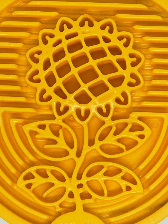 Close-up of yellow Earth eCoin Nylon Lick Mat with sunflower design for dog enrichment and anxiety relief