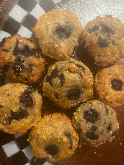 Fresh homemade blueberry muffins with visible blueberry pieces on a checkered plate
