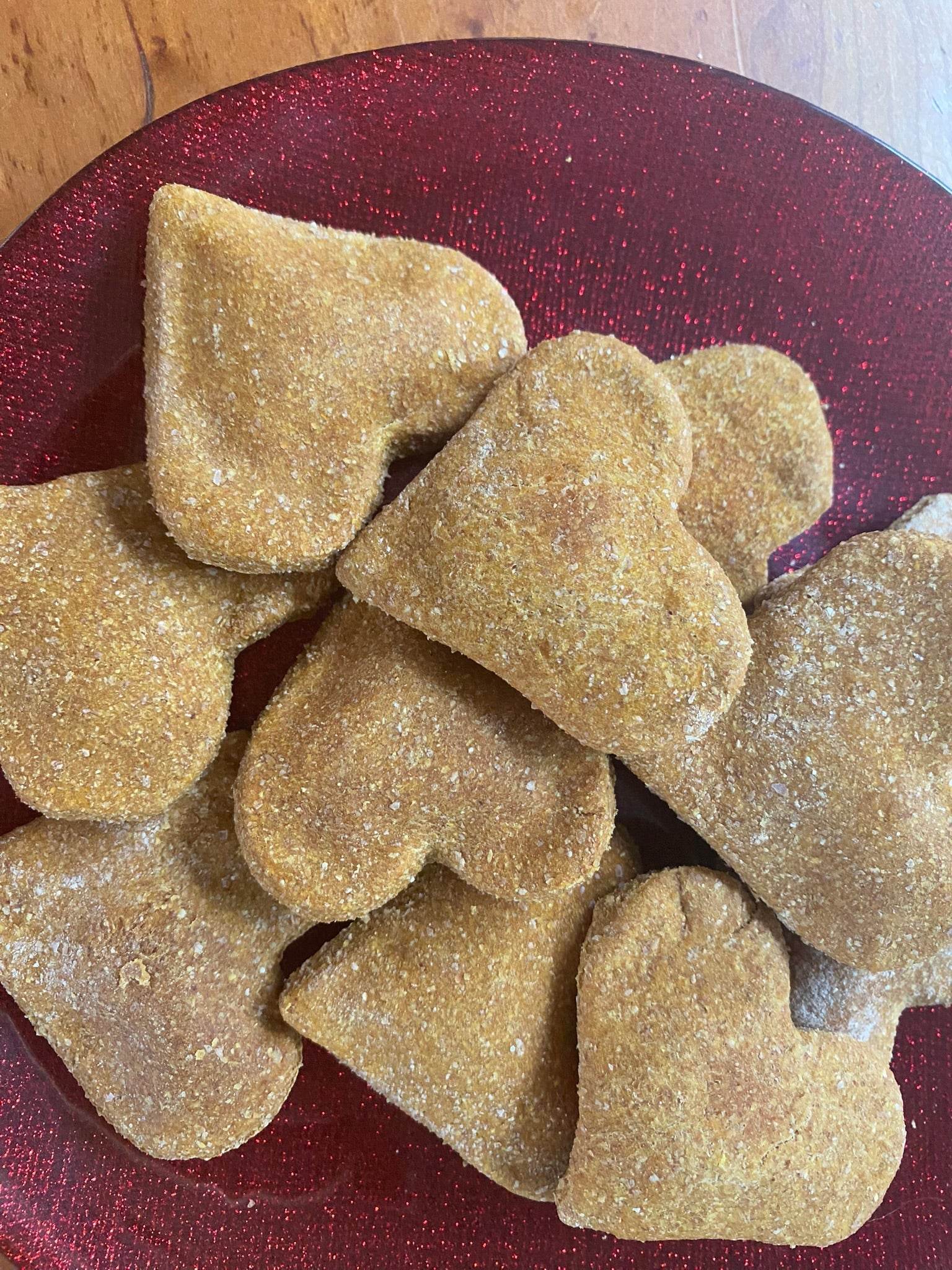 Heart-shaped pumpkin cinnamon dog treats on red plate, organic and preservative-free, perfect fall flavor for dogs