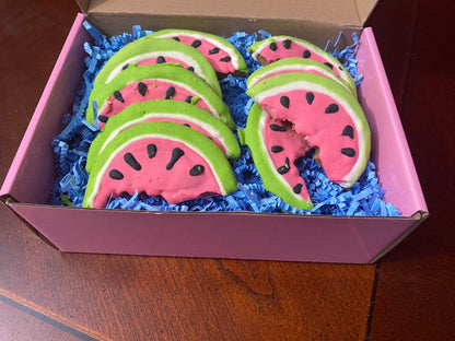 Box of organic watermelon-shaped dog cookies with peanut butter flavor on blue paper filler