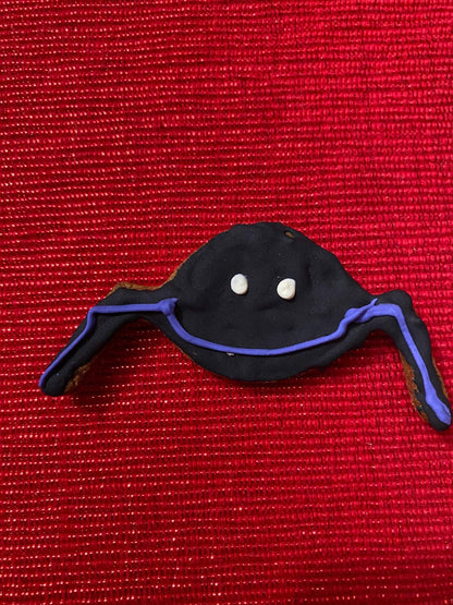 Organic Halloween dog cookie shaped like a ghost with purple accents on red background