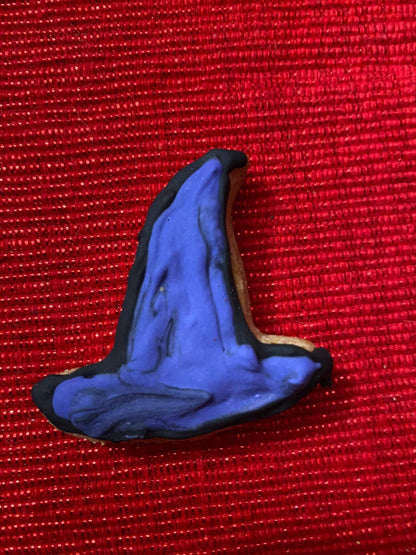 Organic Halloween dog cookie shaped like a purple witch hat with black trim on red background