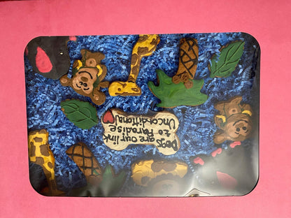 Pink gift box with dinosaurs organic dog cookie box featuring colorful dinosaur and animal-shaped dog treats on blue paper filler