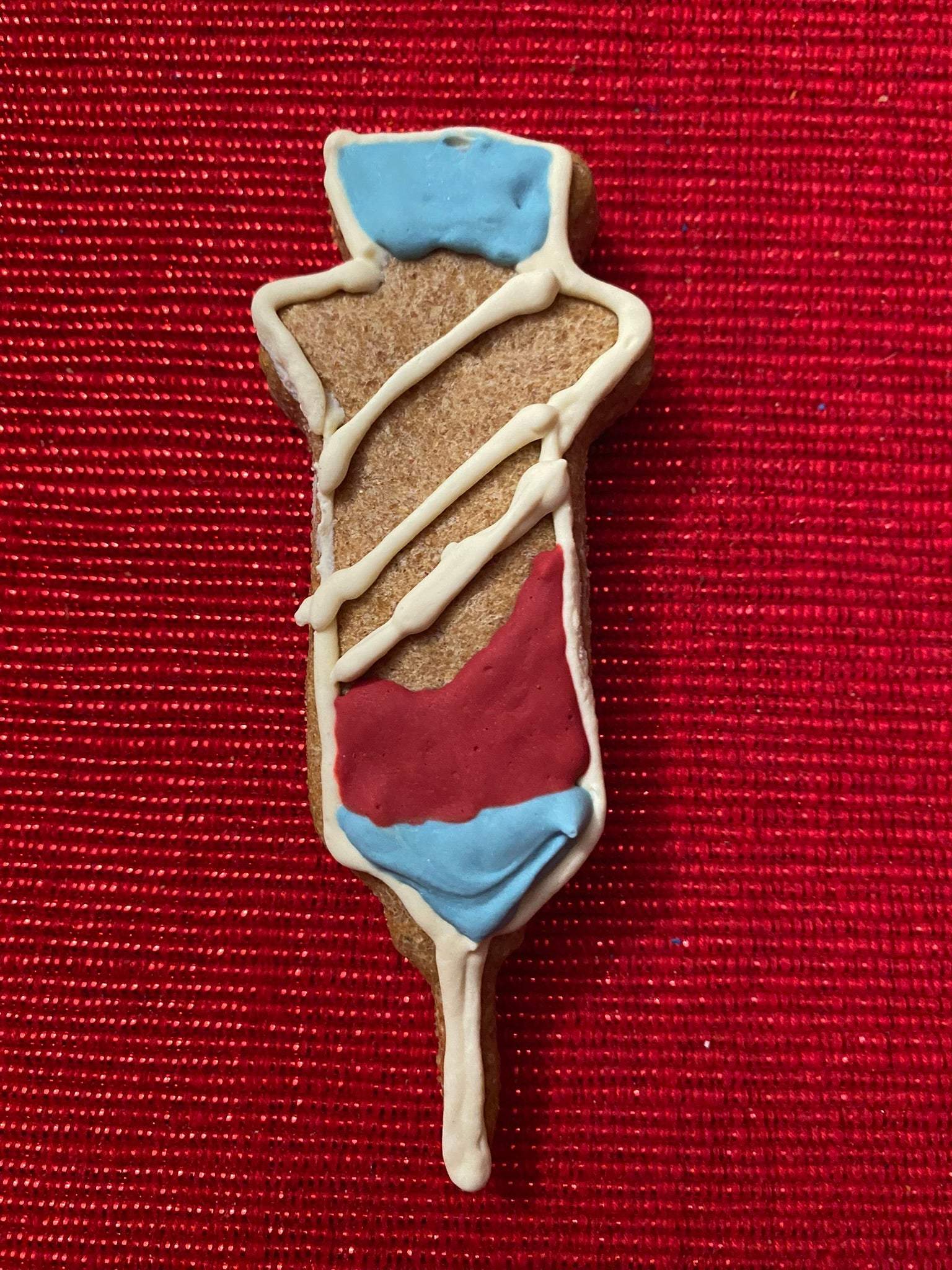 Get Well Organic Dog Cookie Box peanut butter dog cookie shaped like an IV drip with red, white, and blue icing on a red background